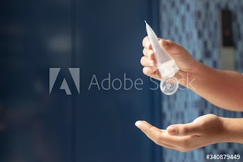 Woman cleaning hands with a hand sanitizer gel to prevent coronavirus contamination