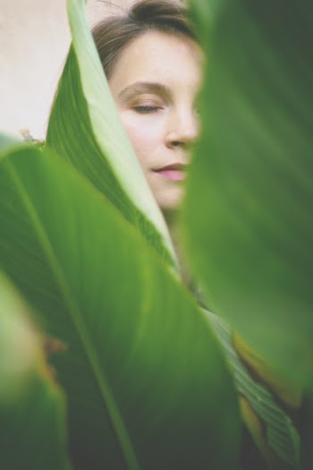 Woman Closing Her Eyes at the Back of Green Leaves