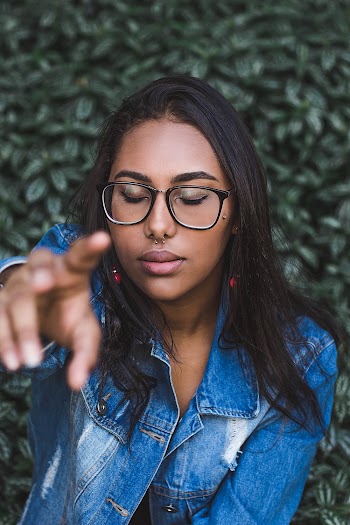 Woman Closing Her Eyes While Pointing Finger In Front