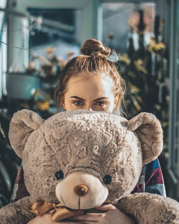 Woman Covering Face With Big Bear Plush Toy