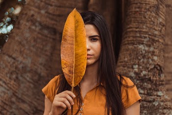 Woman Covering Face With Leaf