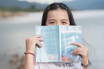 Woman Covering Her Face With A Book