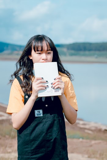 Woman Covering Her Face With A Book