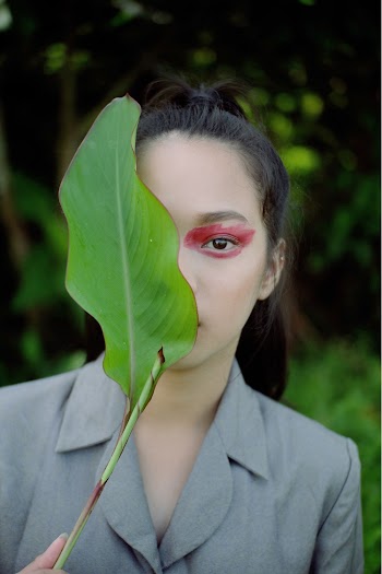 Woman Covering One Eye with a Leaf