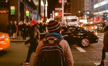 woman crossing highway during nighttime