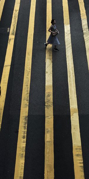woman crossing pedestrian during daytime