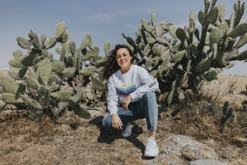 Woman crouching near a cactus