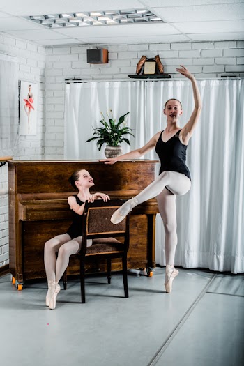 Woman Dancing Ballet Beside Girl Sitting on Chair