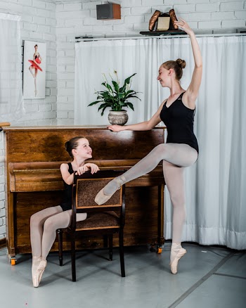 Woman Dancing Ballet in Front of Girl Sitting on Chair