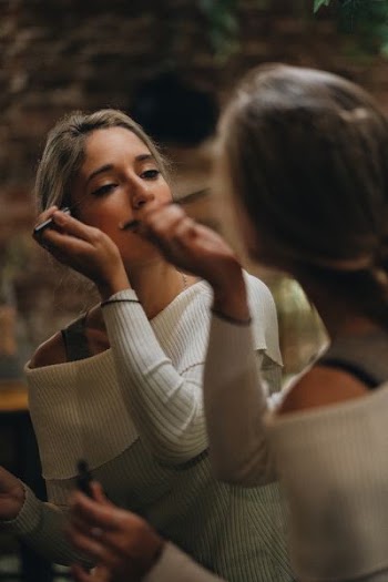 woman doing makeup herself