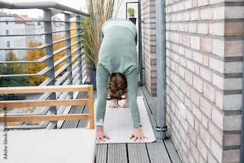 Woman doing yoga on the balcony