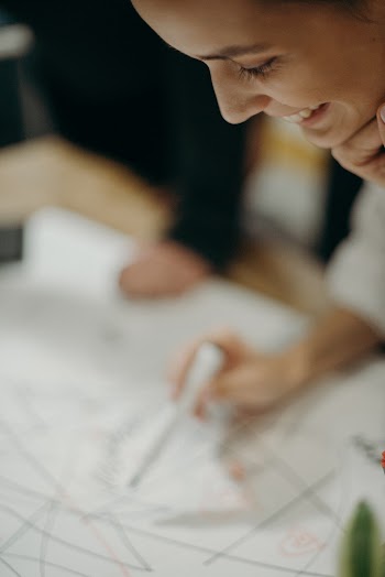 Woman Drawing on Printed Paper