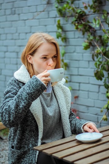 Woman Drinking from White Ceramic Cup