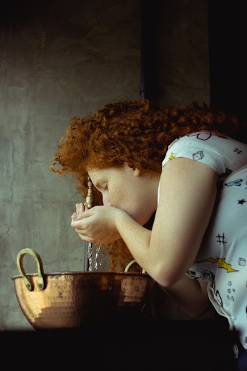 Woman Drinking Water From Faucet