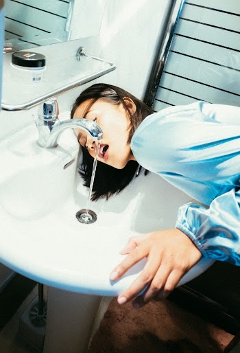 Woman Drinking Water From The Sink