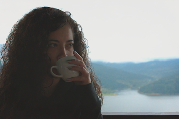 Woman Drinks from White Mug