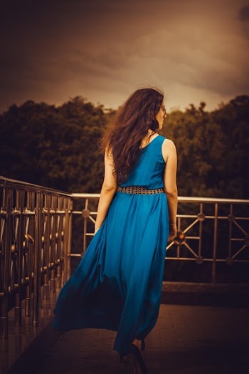 Woman Facing Away Wearing Blue Tank Long Dress Looking Out to Trees