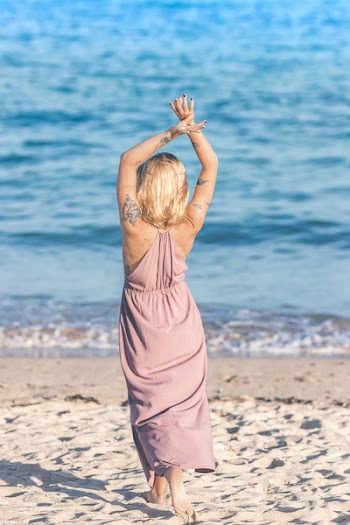 Woman Facing Body of Water Raising Her Hands Up