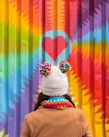 woman facing in front of graffiti wall