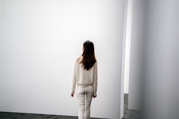 Woman Facing White Wall