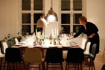 woman fixing dinnerware at table