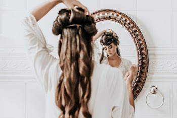 Woman Fixing Her Hair In Front Of A Mirror