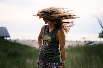 Woman Flipping Hair Standing on Green Grass
