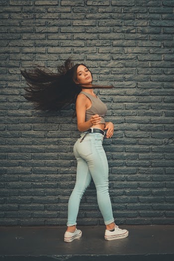 Woman Flipping Her Hair on Front of Grey Wall