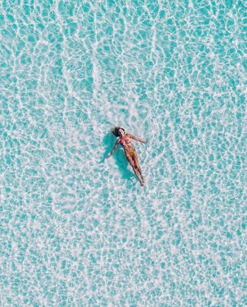 woman floating on body of water
