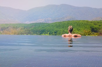 Woman Half Submerge Facing on Mountain