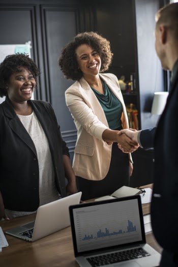 Woman Handshaking Man's Hand While Smiling