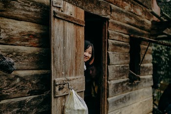 Woman Hiding Behind Cabin Door