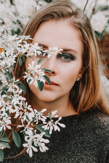 Woman Hiding Behind White Petaled Flower