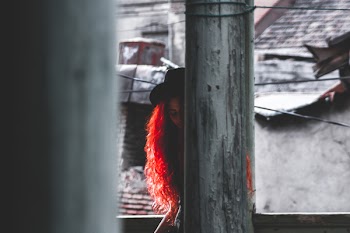 Woman Hiding With a Post