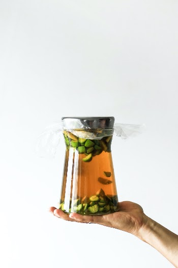 Woman holding a 1 litre bottle of homemade organic brandy with early nuts for flavor.
https://creativemarket.com/NordWood Buy Insta designs here!
