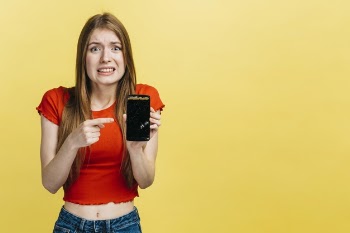 Woman holding a broken phone with copy space Free Photo