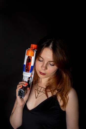 Woman Holding a Colorful Nerf Gun