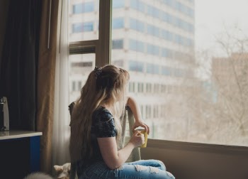 Woman Holding a Cup Looking at the Window