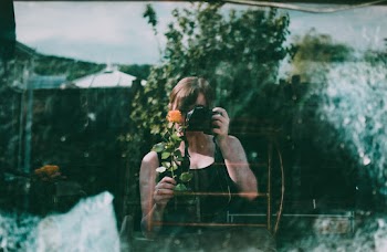 Woman Holding A Flower And Camera