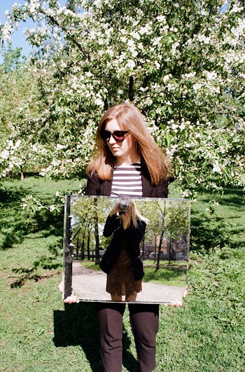 woman holding a mirror outdoors