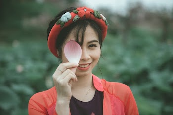 Woman Holding a Pink and White Flower Petal