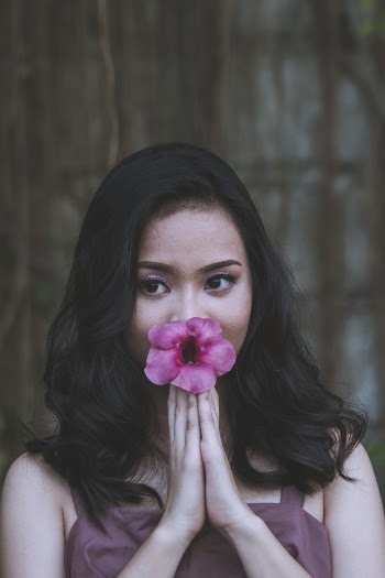 Woman Holding a Pink Hibiscus Flower