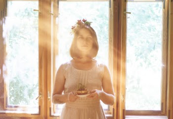 Woman Holding A Plant With Sunlight Through The Window