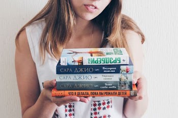 woman holding assorted books