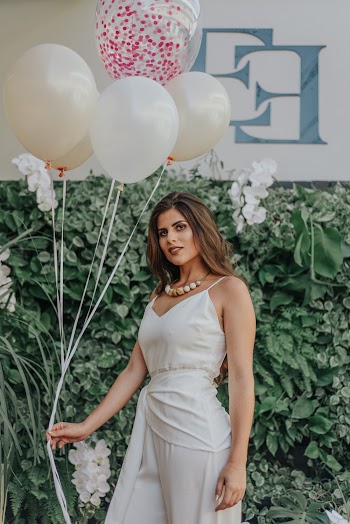 Woman Holding Balloons Near Green Plants