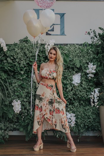 Woman Holding Balloons Standing Beside Flower Wall