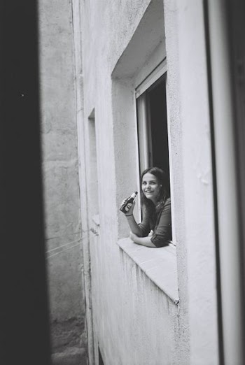 woman holding beer bottle on window