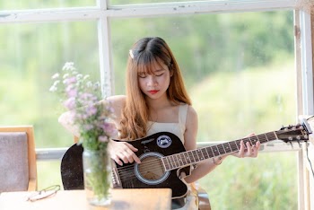 Woman Holding Black Acoustic Guitar