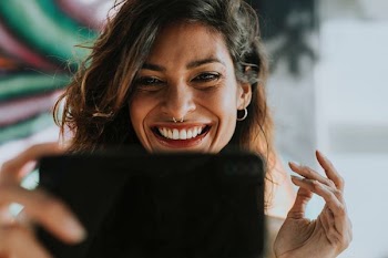 woman holding black Android smartphone