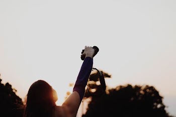 woman holding black DSLR camera
